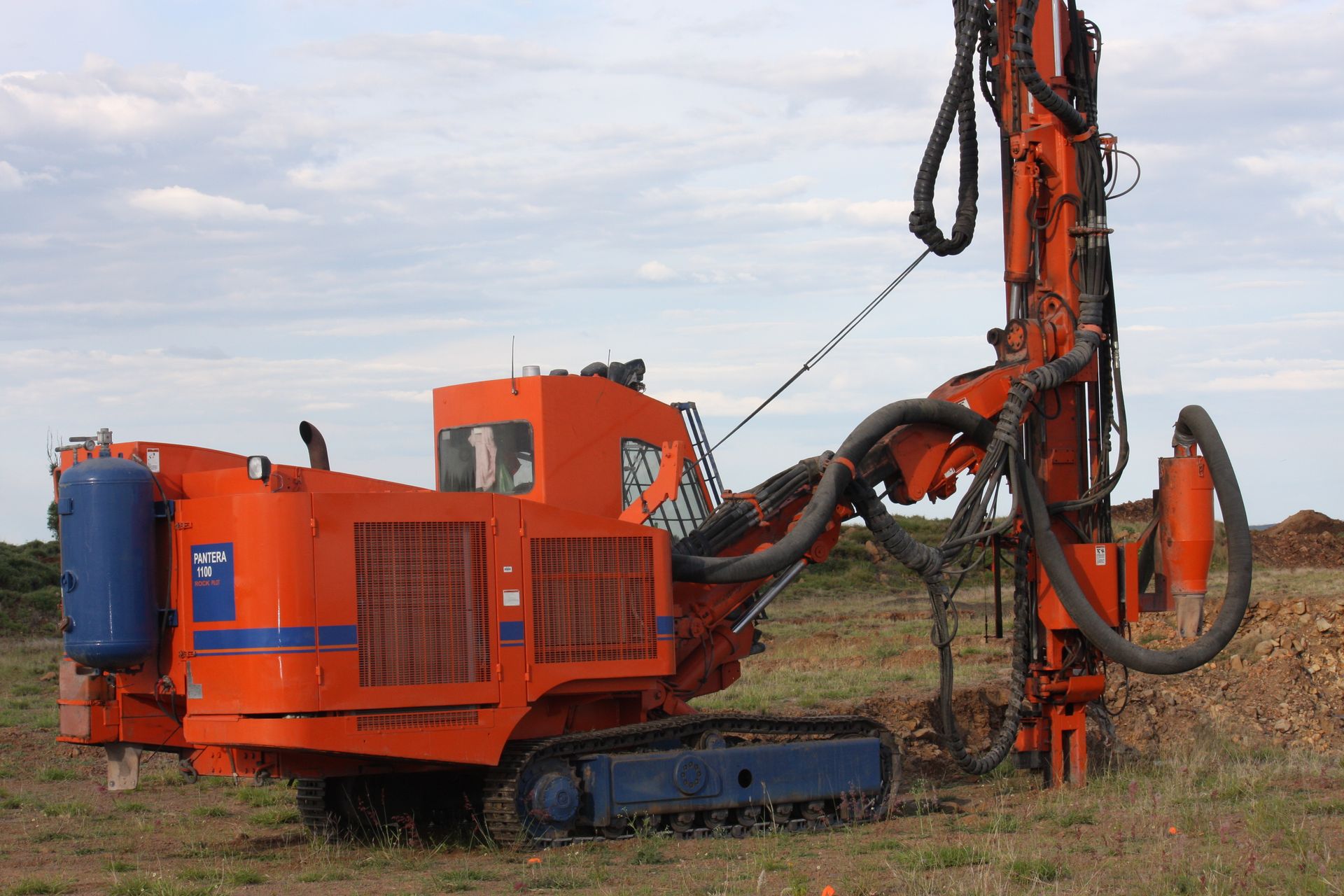 A yellow excavator is digging a hole in the ground.