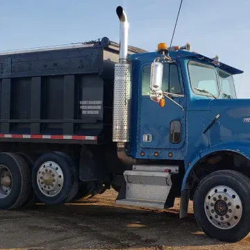 Blue dump truck on a dirt road, with a black dump bed, and a chrome exhaust stack.