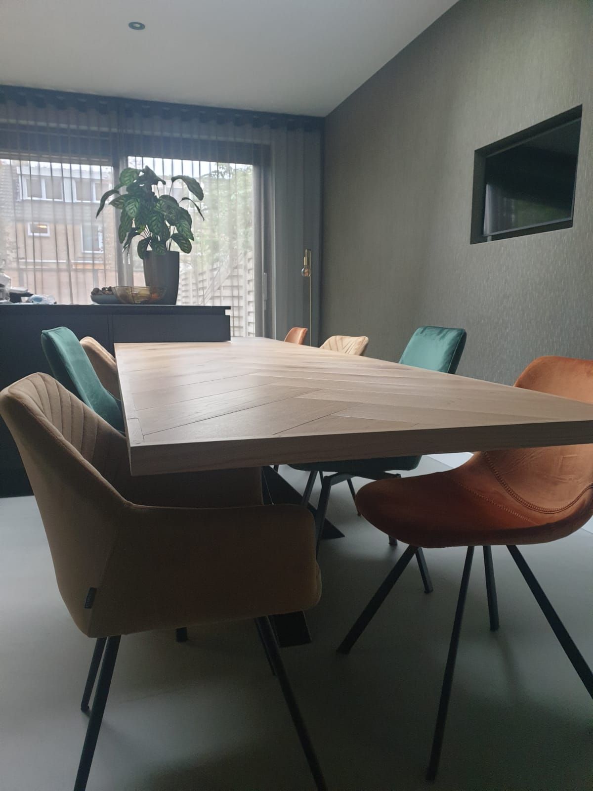 Een eetkamer met een tafel en stoelen en een raam.