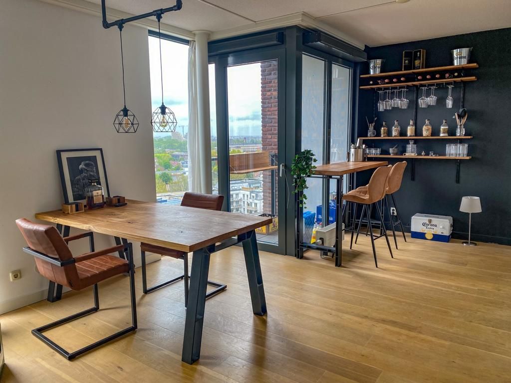 Een eetkamer met een tafel en stoelen en een balkon.