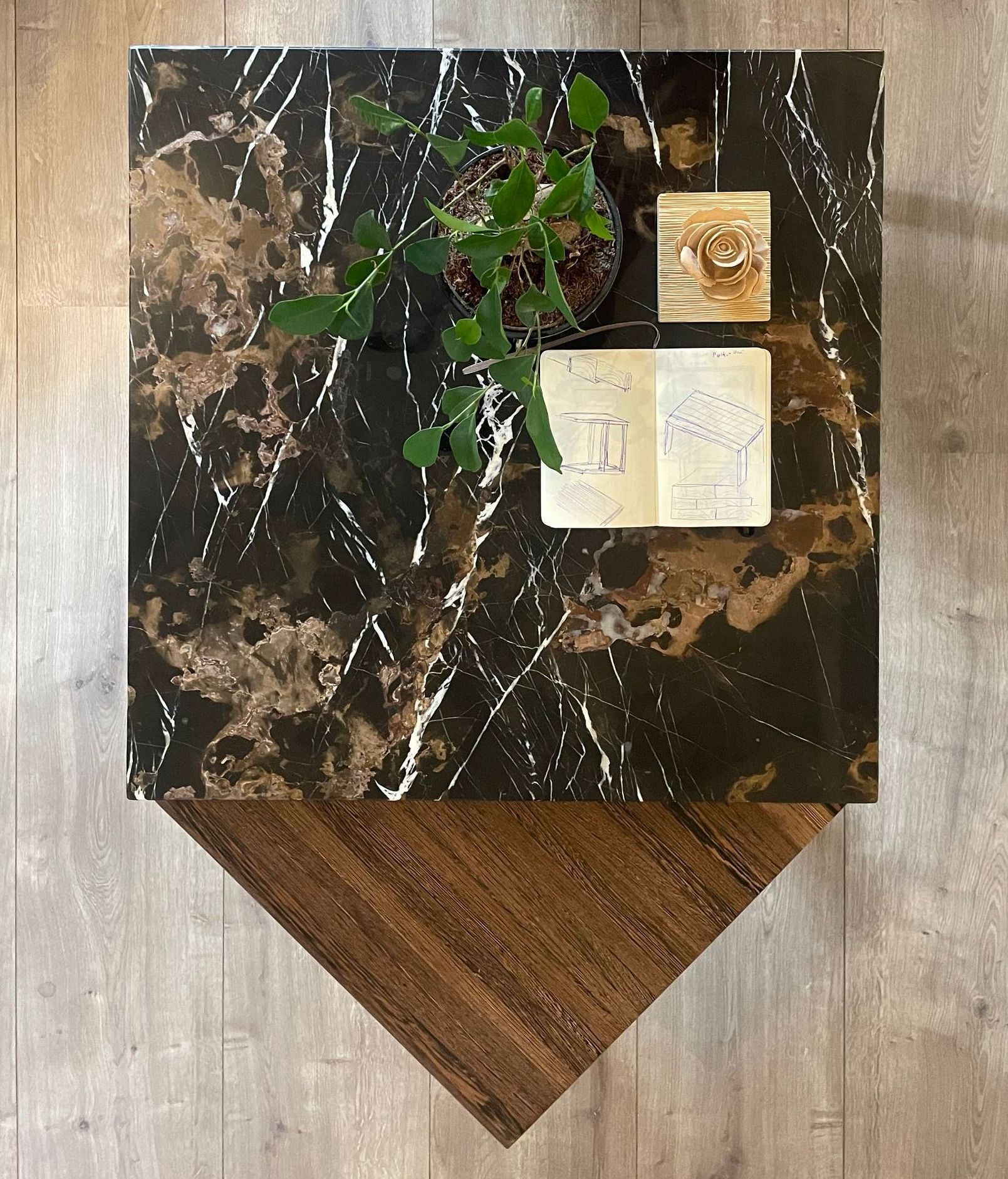 Een marmeren tafel met een plant en een boek erop