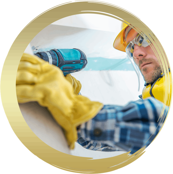 a man wearing a hard hat and safety glasses is using a drill on a wall