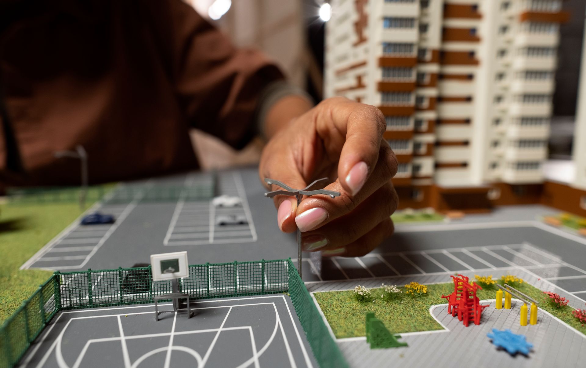 A person is working on a model of a basketball court.