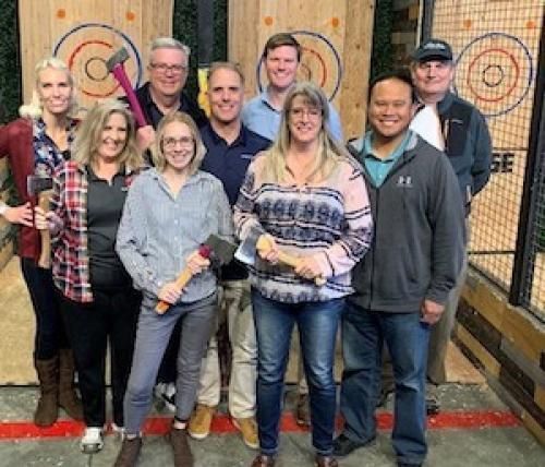 A group of people standing next to each other holding axes.
