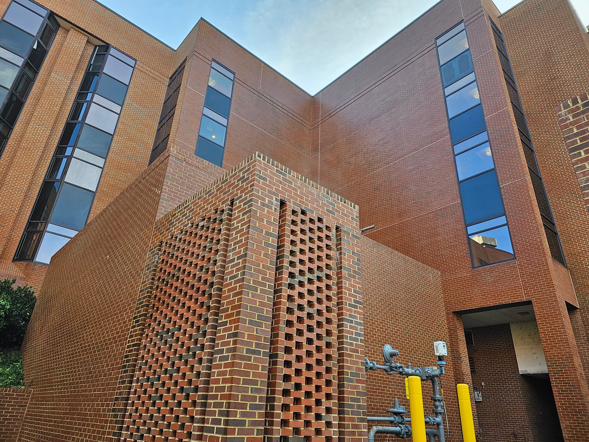 Brick building with rectangular windows; sunny exterior shot.