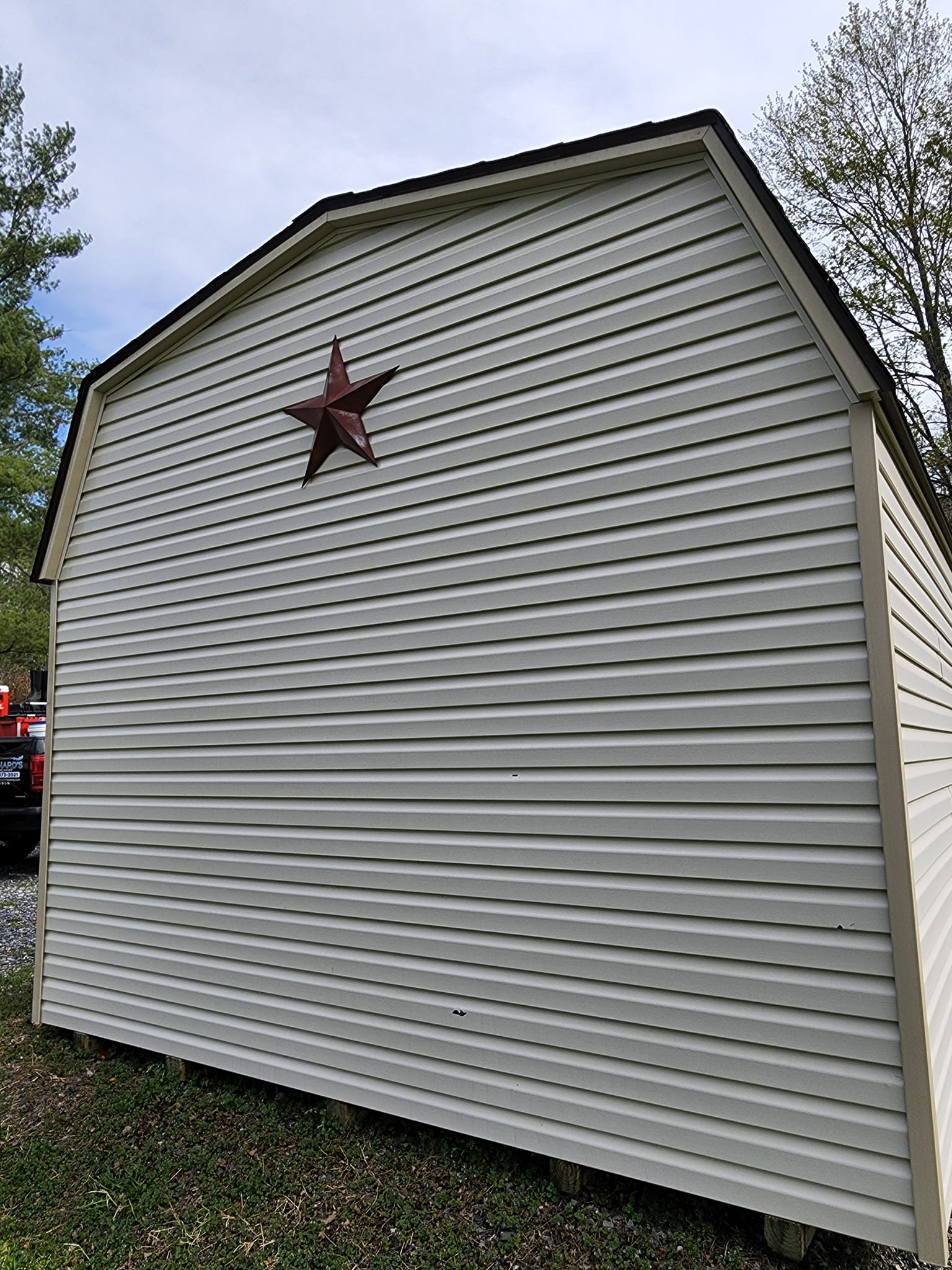 White shed with a red star decoration; outdoors.