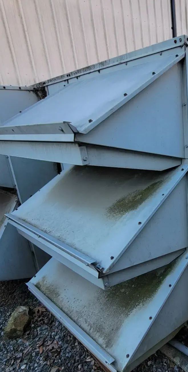 Stack of weathered, gray, metal air intake vents.