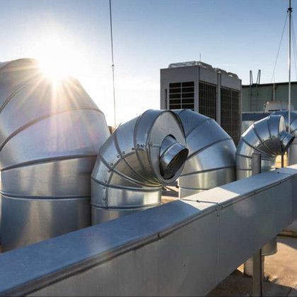 A bunch of metal pipes are sitting on top of a building.
