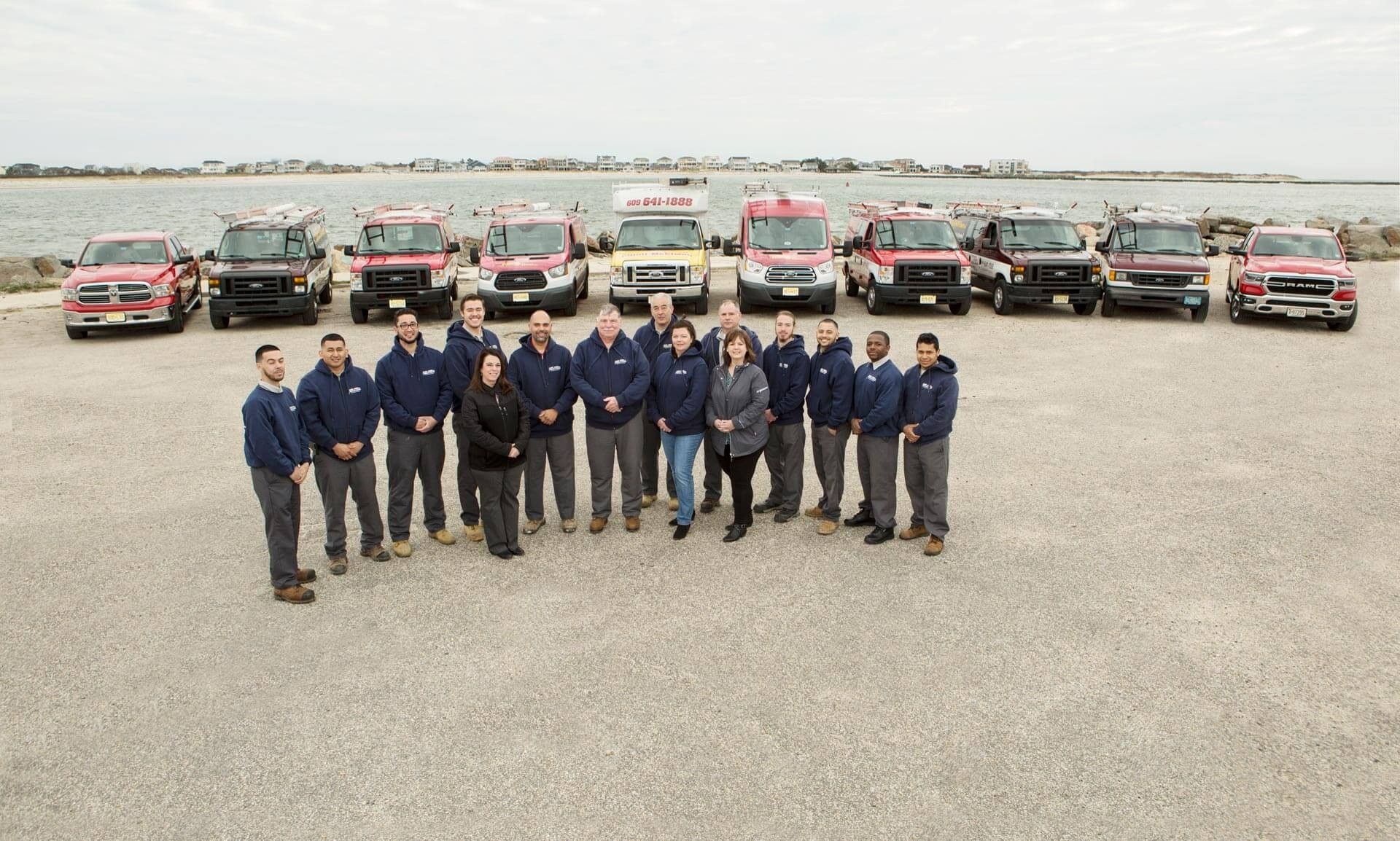 A group of people standing in front of a row of trucks.