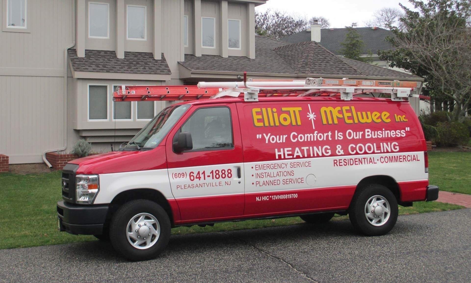 Red and white Elliott McElwee Inc. HVAC service van parked in front of a house.