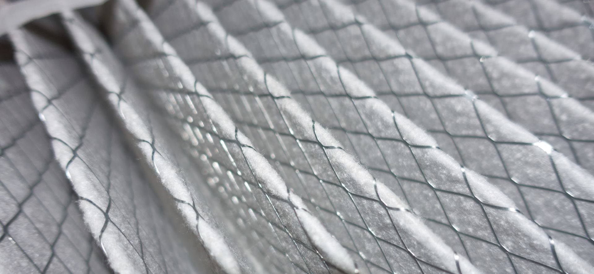 Close-up of a pleated air filter with a wire mesh backing.