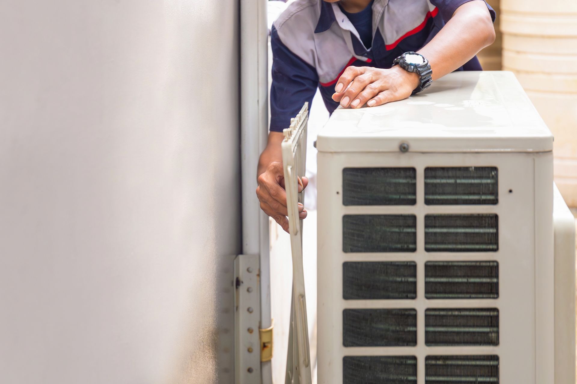 HVAC technician installing an outdoor air conditioning unit.