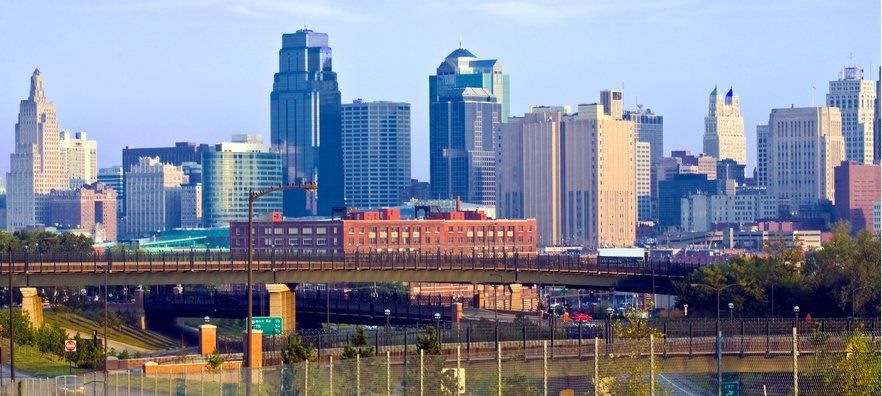 a bridge over a river with a city skyline in the background