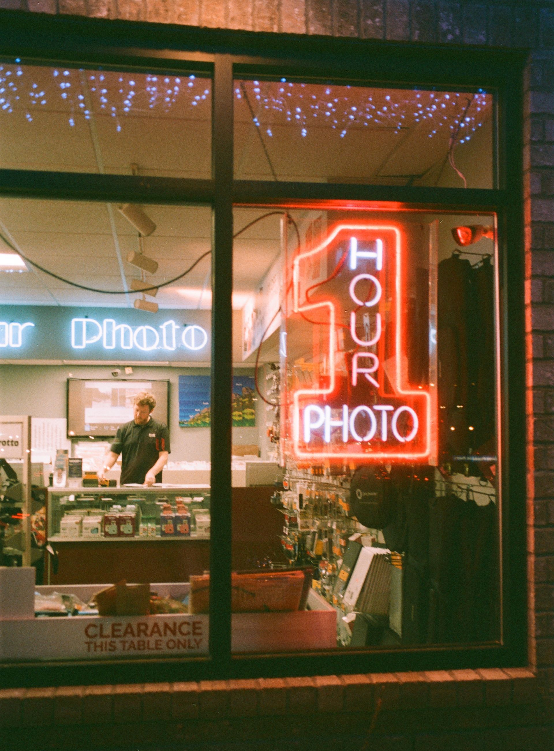 One hour photo neon sign in front window of Sharp Photo and Portrait