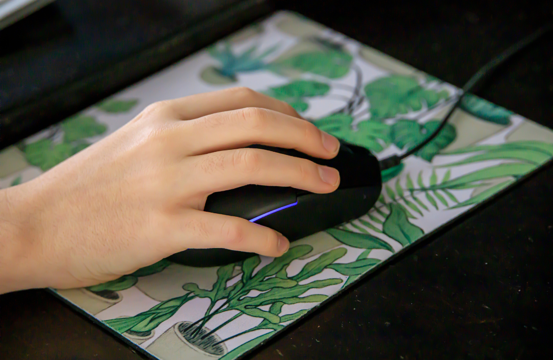 Hand holding a mouse on top of a mouse pad
