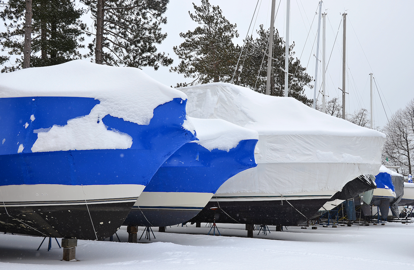 A blue and white boat is covered in snow