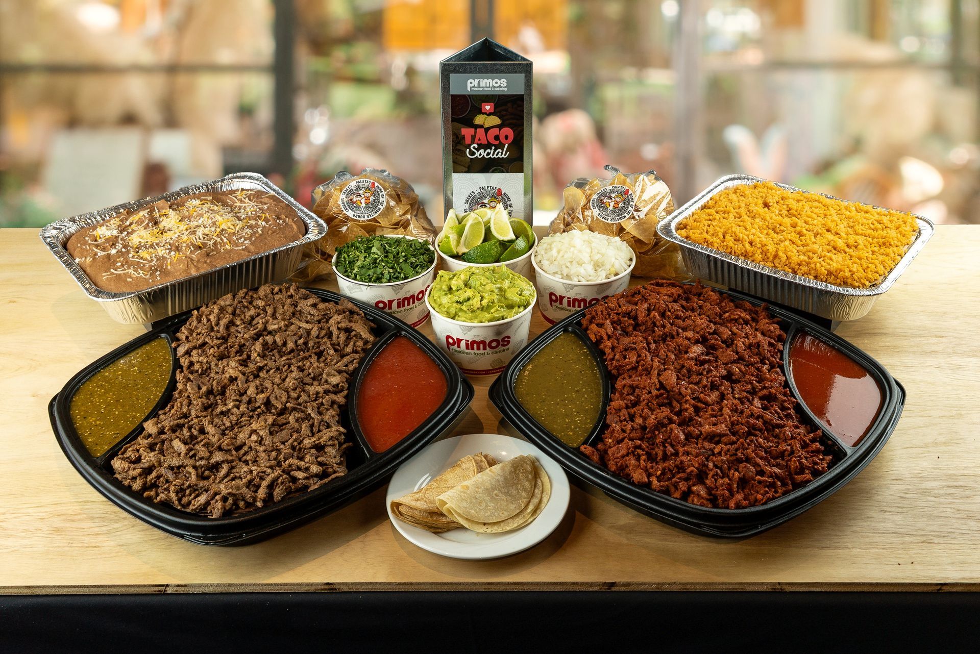 Assorted food dishes on a table with bowls of toppings and sauces in a restaurant setting
