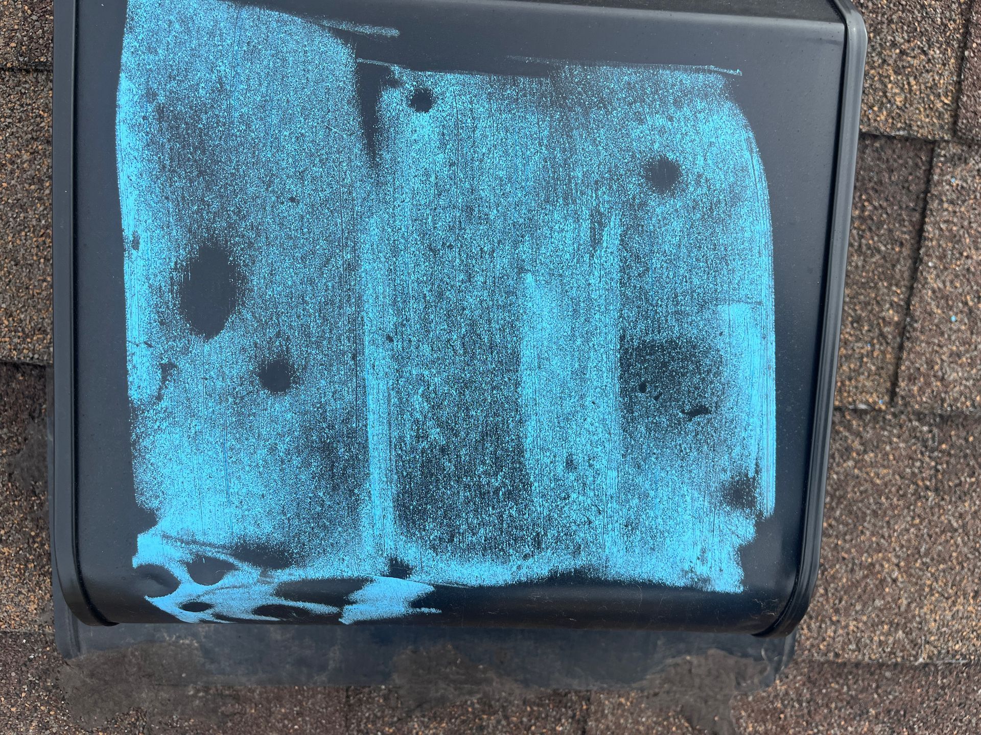 Blue powder smeared across a black hard case sitting on brown brick pavers.