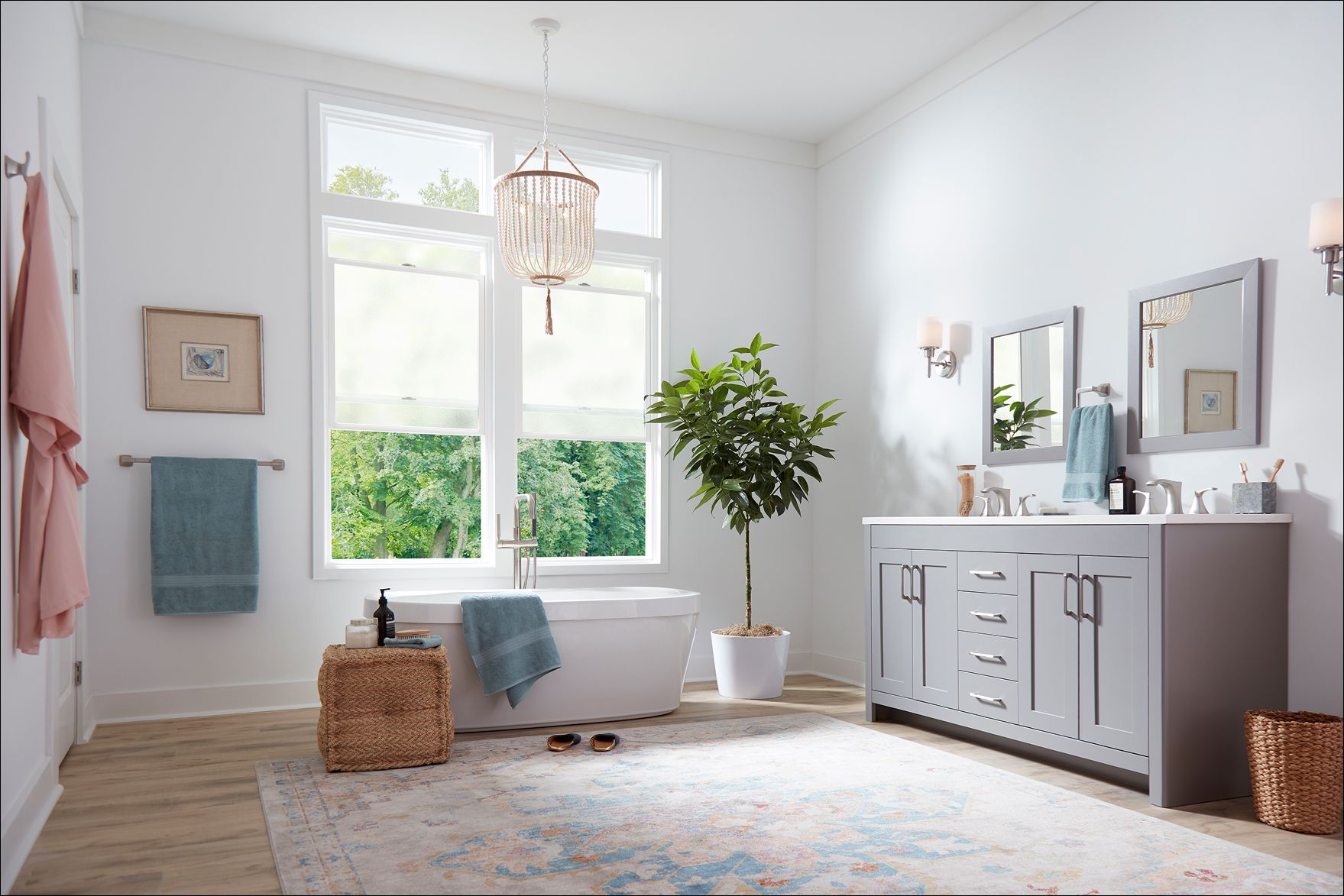 Bright white living room with large windows, blue accents, a sideboard, plant, and patterned rug
