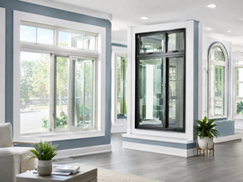 Bright modern room with large white-framed windows, gray floors, and a potted plant