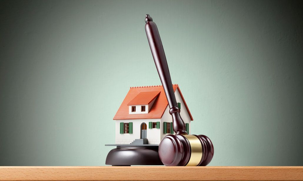 A man is sitting at a table with a judge holding a wooden gavel. A man is sitting at a table with a judge holding a wooden gavel.