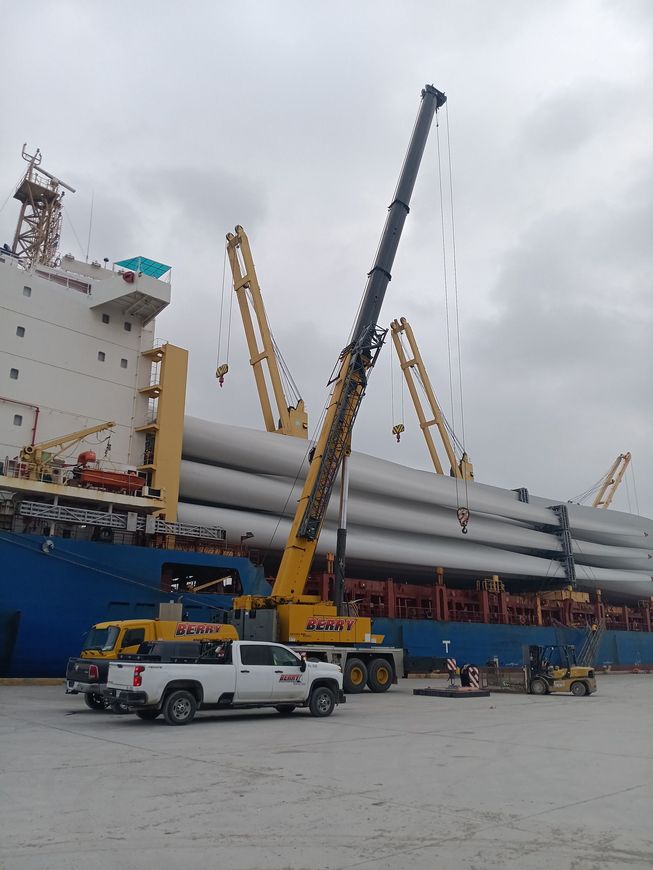 A truck is parked in front of a large ship