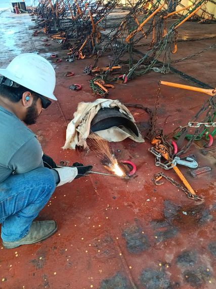 A man wearing a welding helmet is using a welding torch,