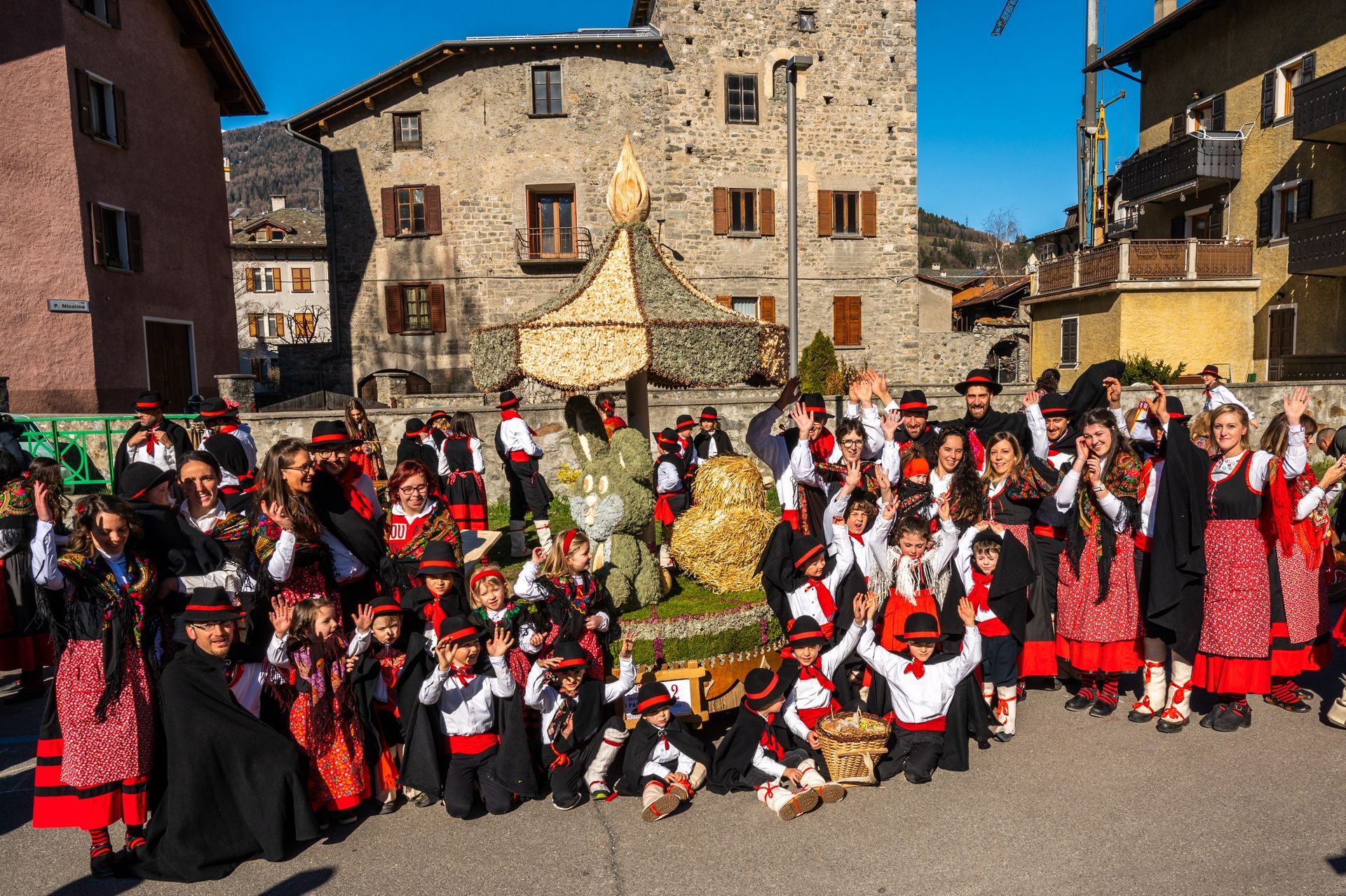 Un folto gruppo di persone posa per una foto davanti ad un edificio in pietra.