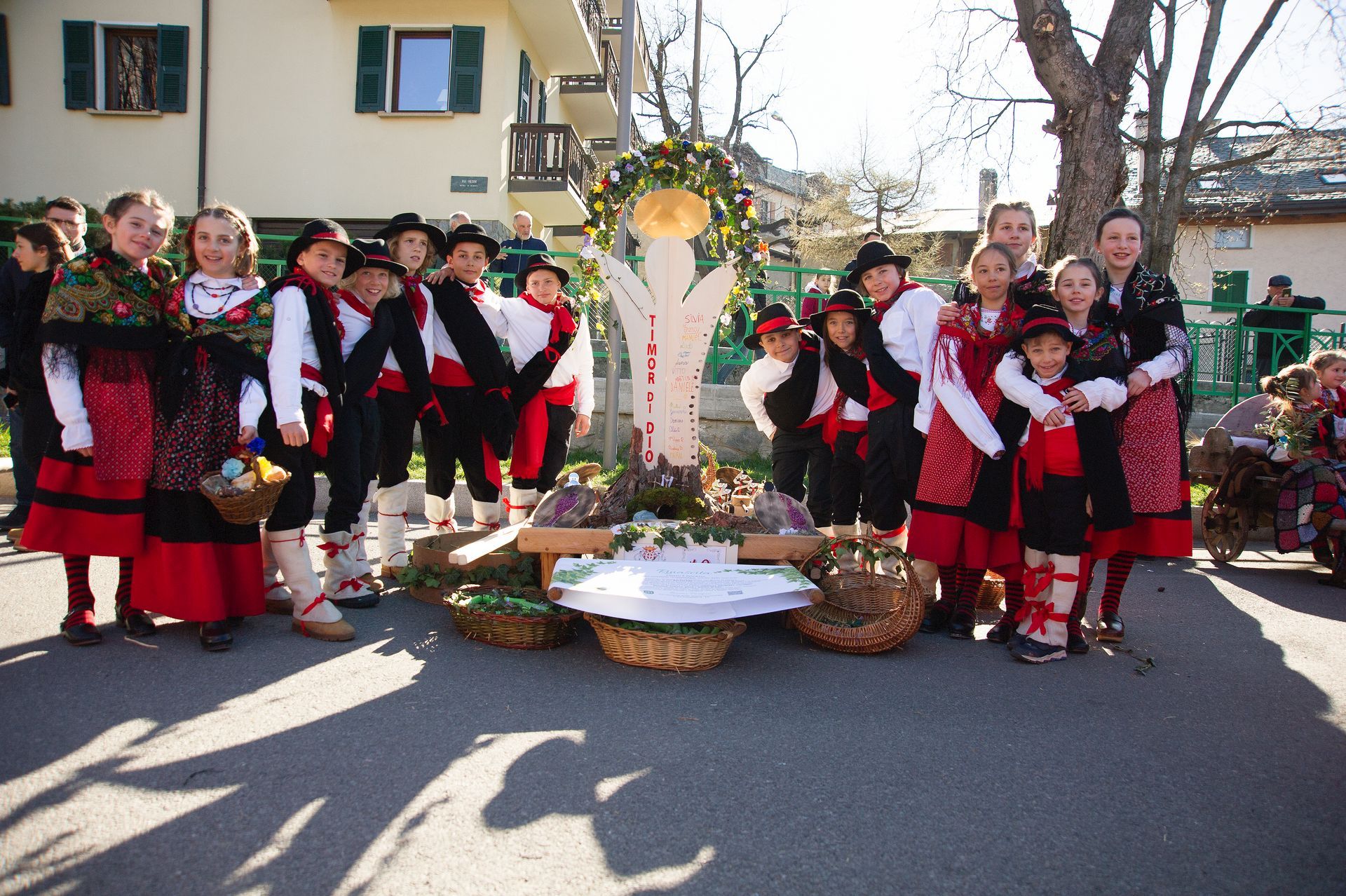 Un gruppo di bambini posa per una foto davanti a un albero
