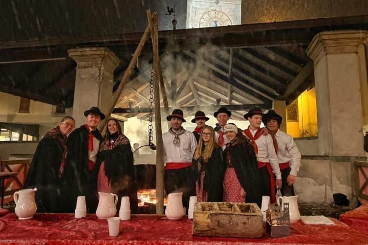 Un gruppo di persone posa per una foto davanti a un fuoco.