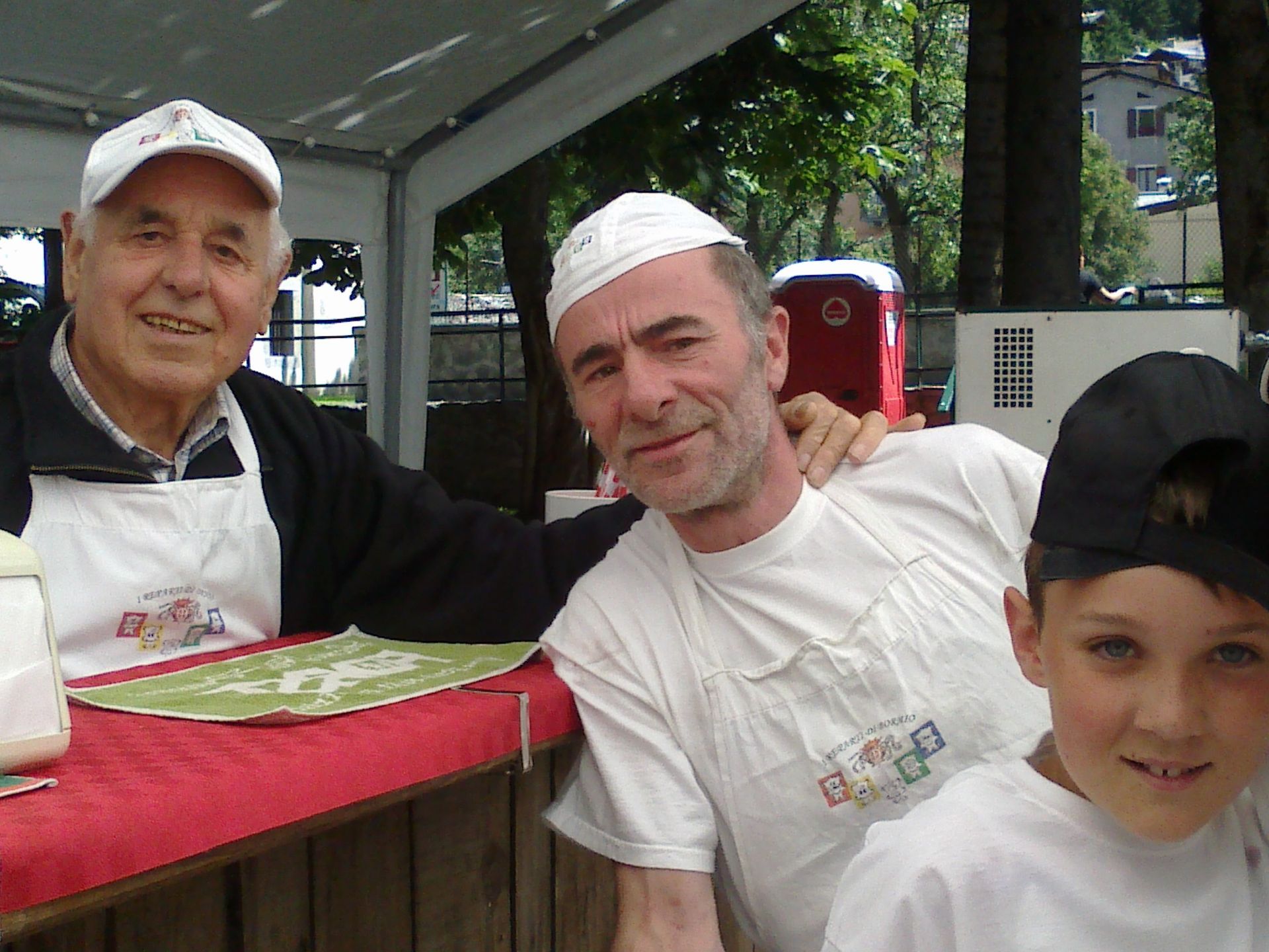 Due uomini e un ragazzo in posa per una foto con uno degli uomini che indossa una maglietta con la scritta bingo