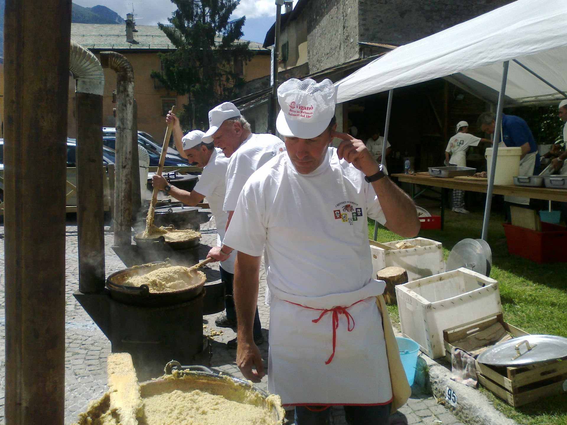 Un uomo che indossa un cappello da chef e un grembiule sta cucinando il cibo