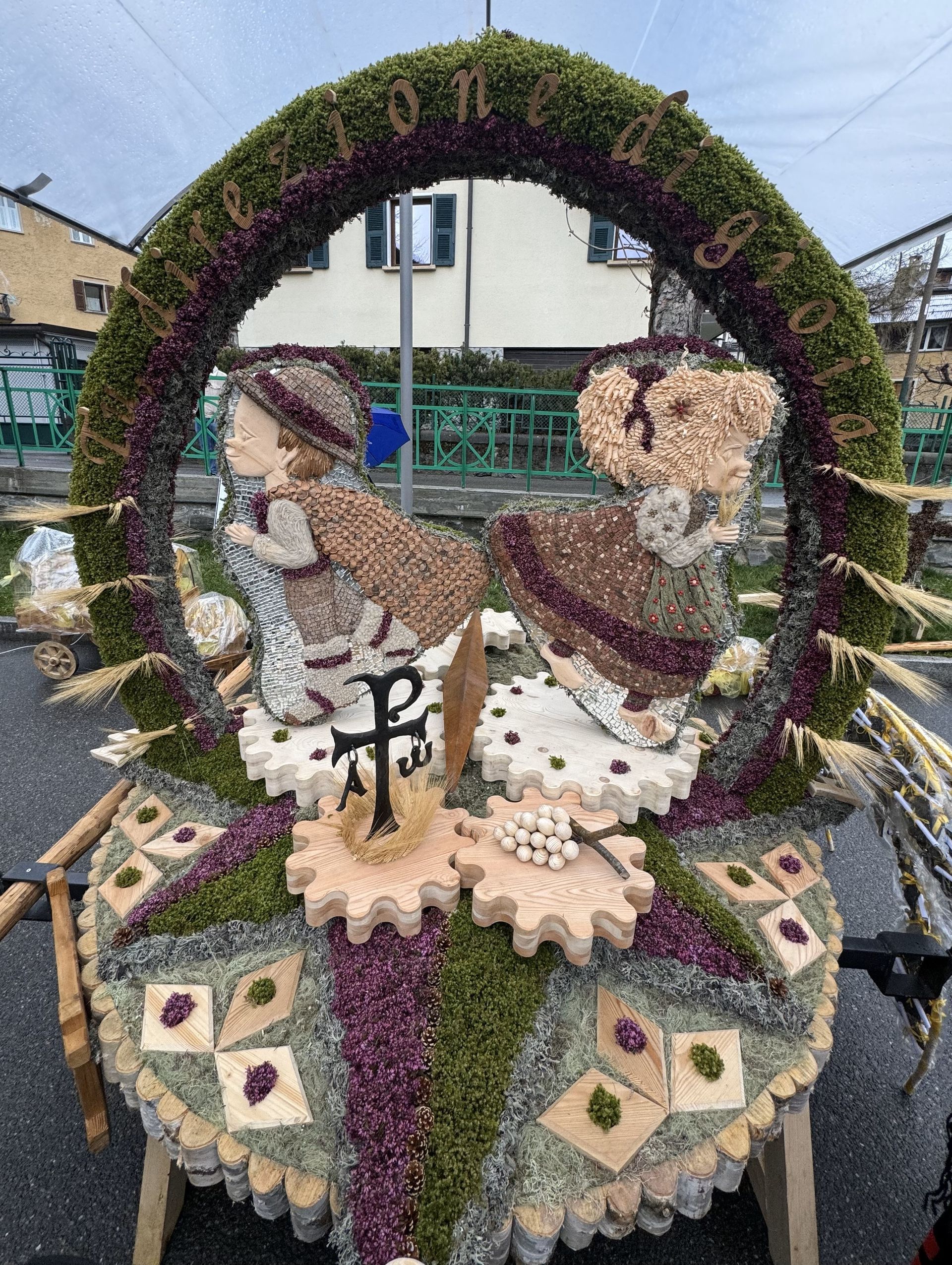 Una scultura fatta di fiori e ingranaggi è seduta sul lato della strada.