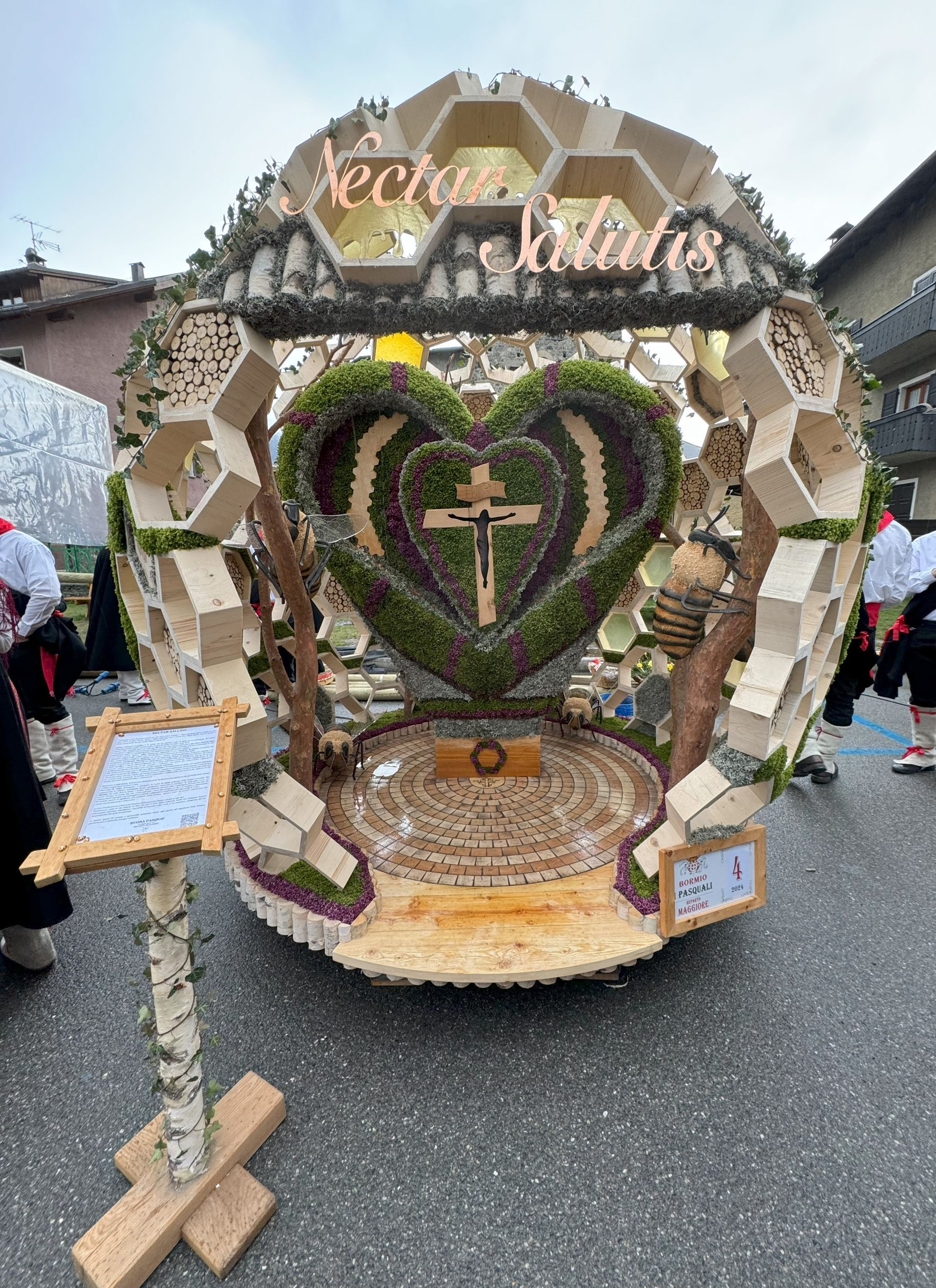 Per strada c'è un carro di legno con un cuore e una croce sopra.
