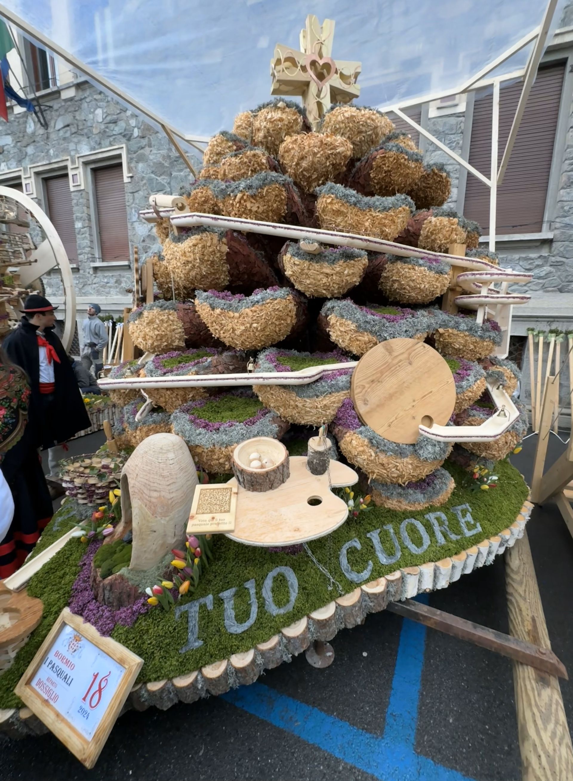 A terra è seduto un albero di Natale fatto di paglia.