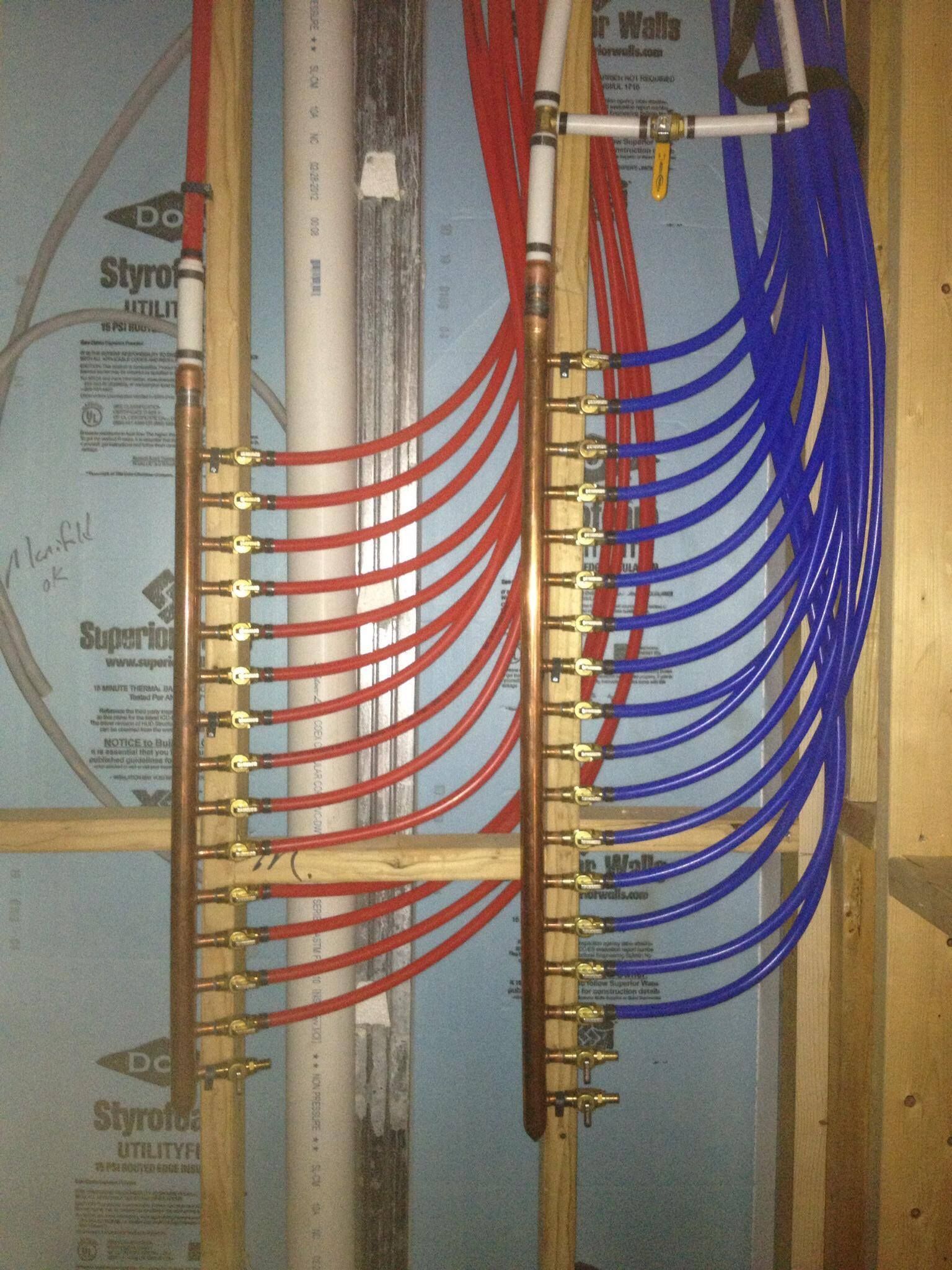 A bunch of red and blue pipes are hanging on a wall