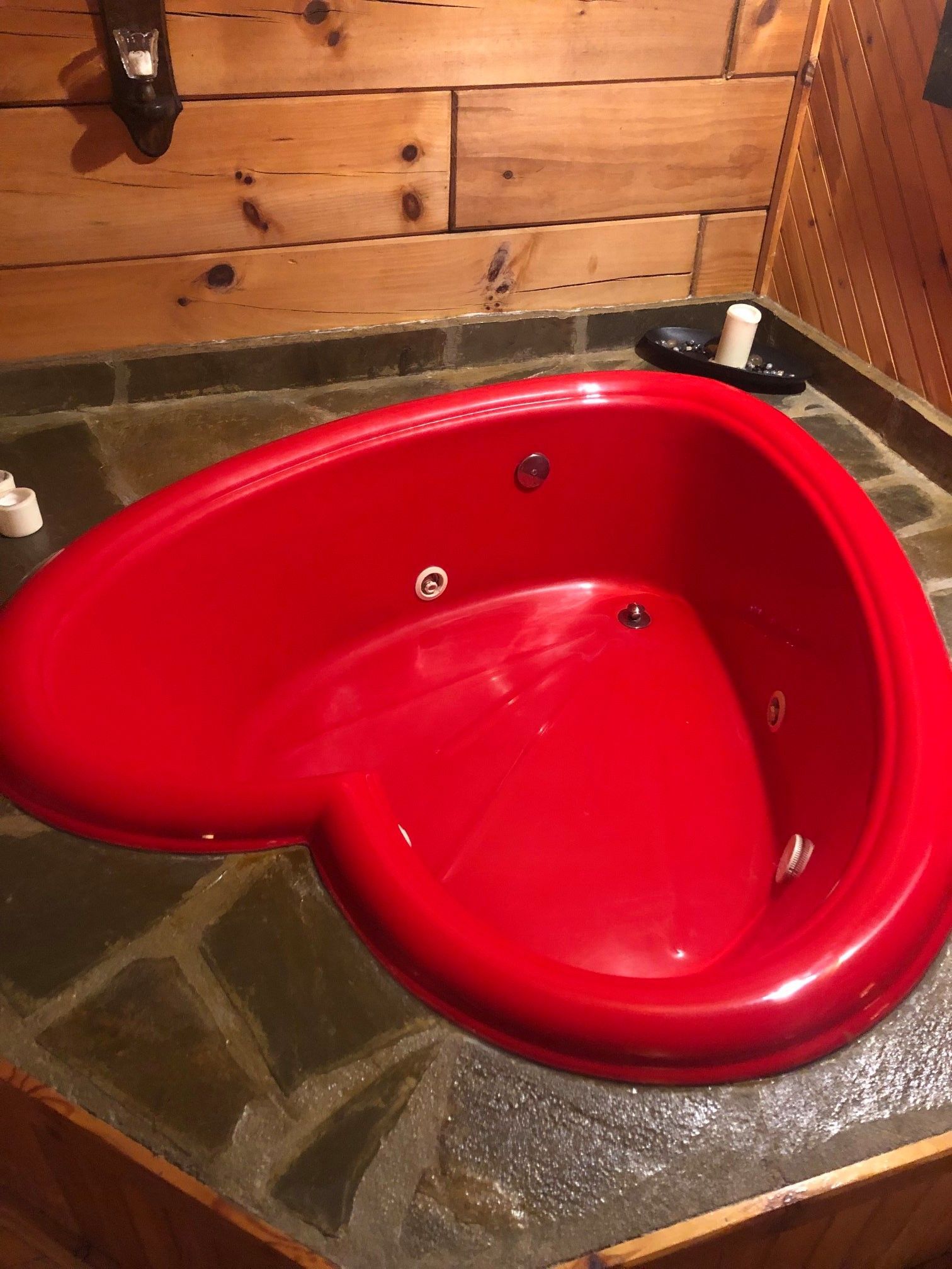 A red heart shaped bathtub in a bathroom