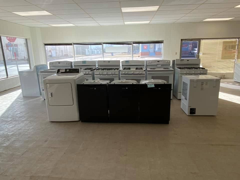 Empty retail showroom with row of large printers/copiers and a black counter in the center