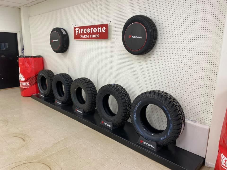 Firestone Tire display with black tires and red sign on a showroom wall