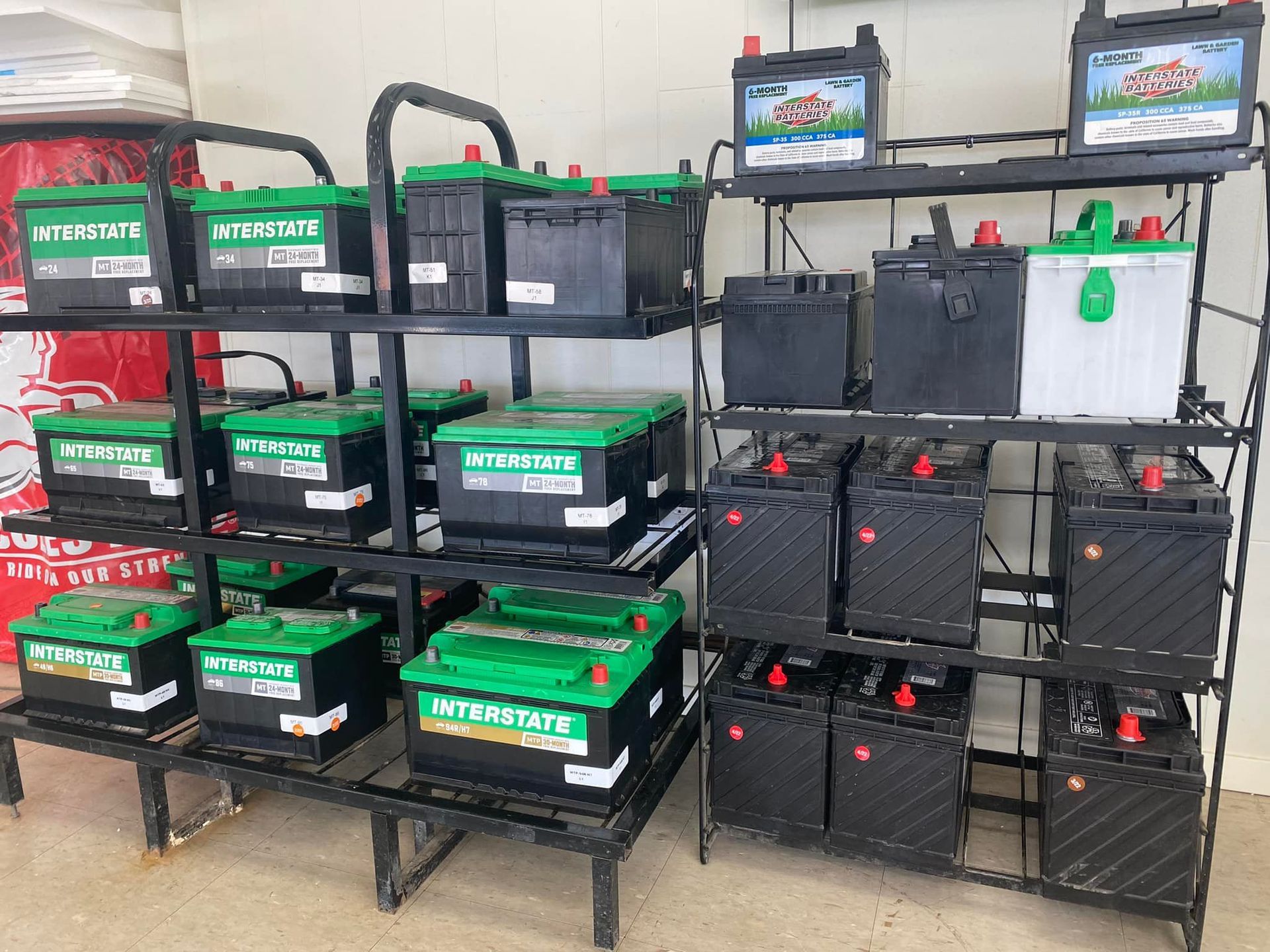 Rows of green-and-black battery packs on shelves in a workshop or storage area