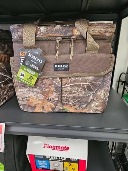 Camouflage lunch bag with handles and shoulder strap on a store shelf