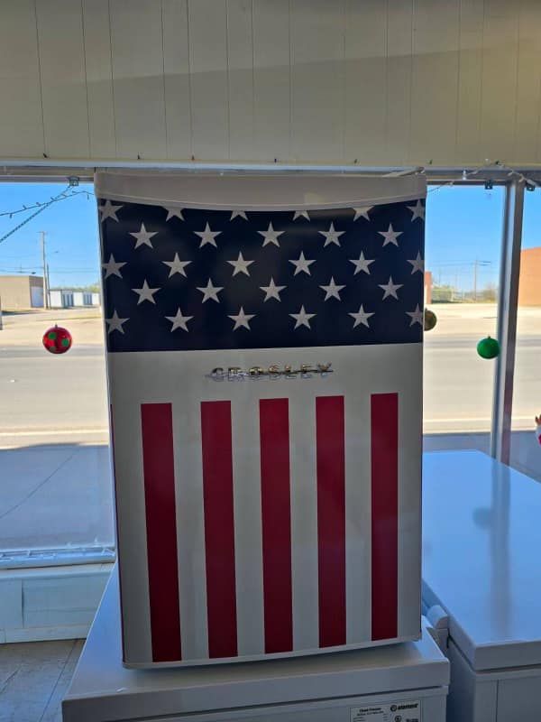 Vertical American flag banner hanging in a bright indoor storefront window