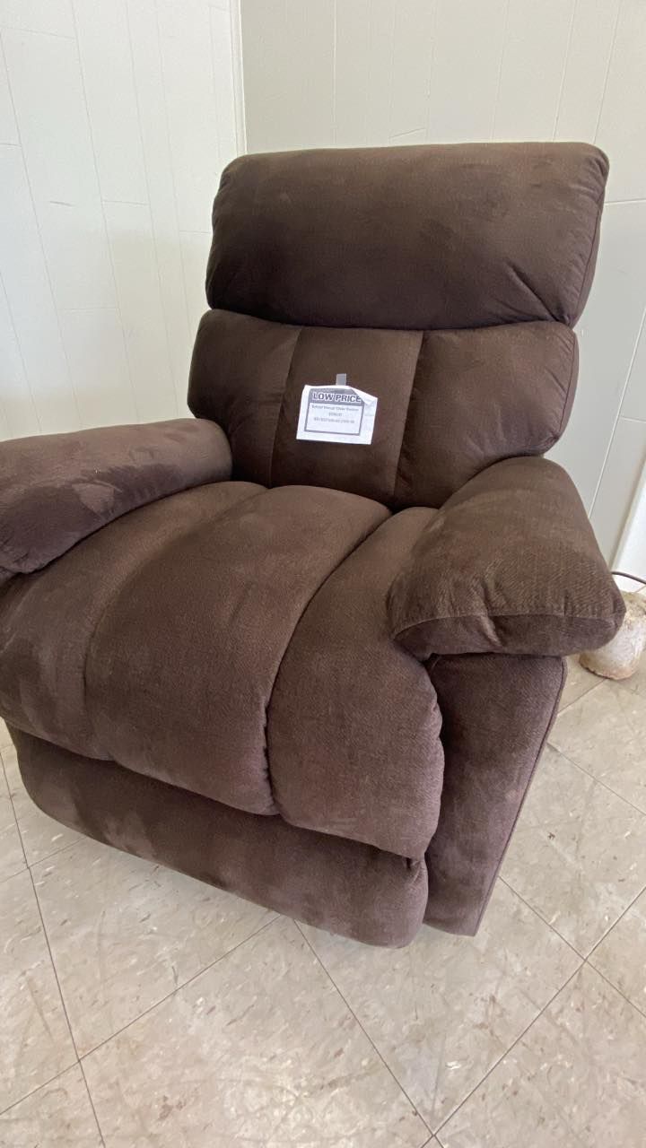 Brown reclining armchair with a high back and a small tag on the seat in a beige room