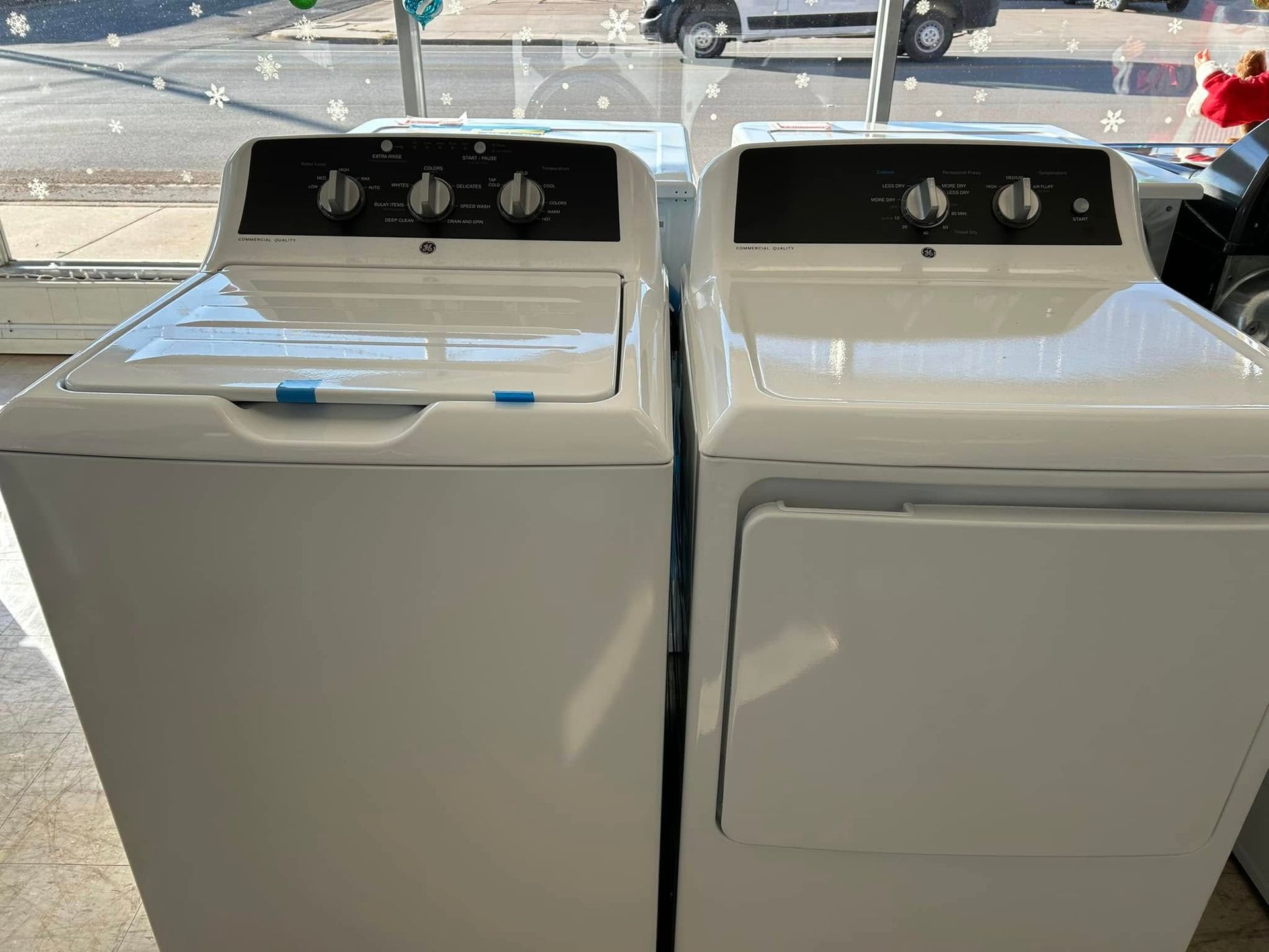 Two white laundry machines side by side in a store display window