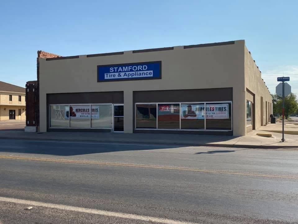 Stamford Auto Repair storefront with large windows and blue sign on a sunny street