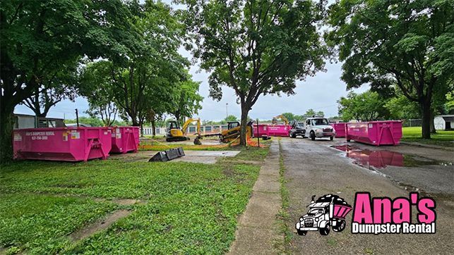 Pink food stalls along a tree-lined park path on a rainy day