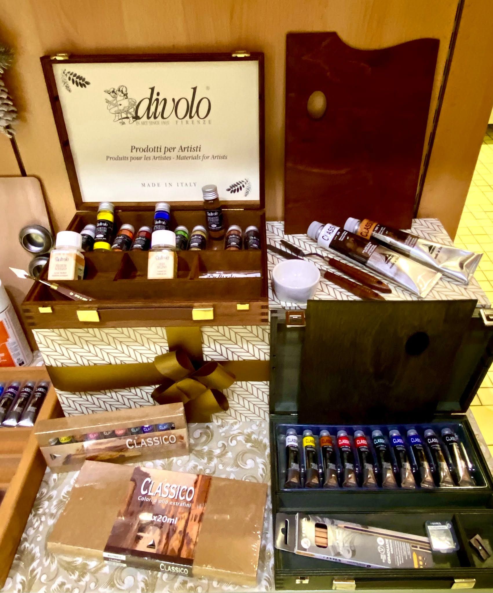 Esposizione di diverse bottiglie di liquore e set regalo su tavoli in un ambiente interno accogliente.