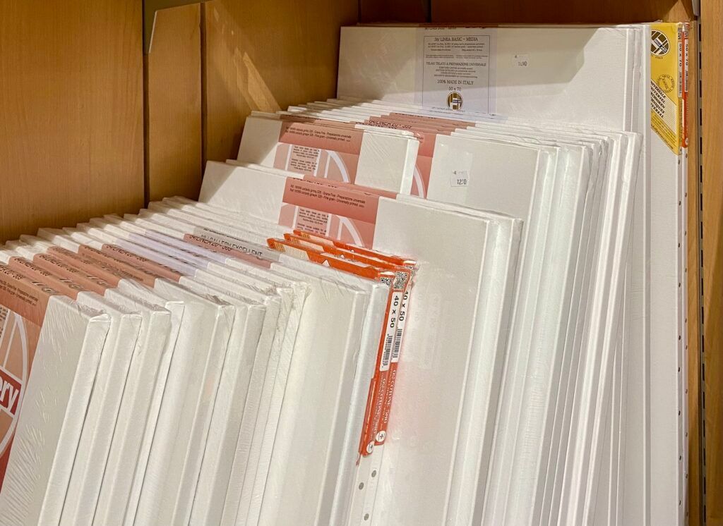 Pannelli di polistirolo bianco impilati e imballaggi con etichette rosse su uno scaffale di legno.