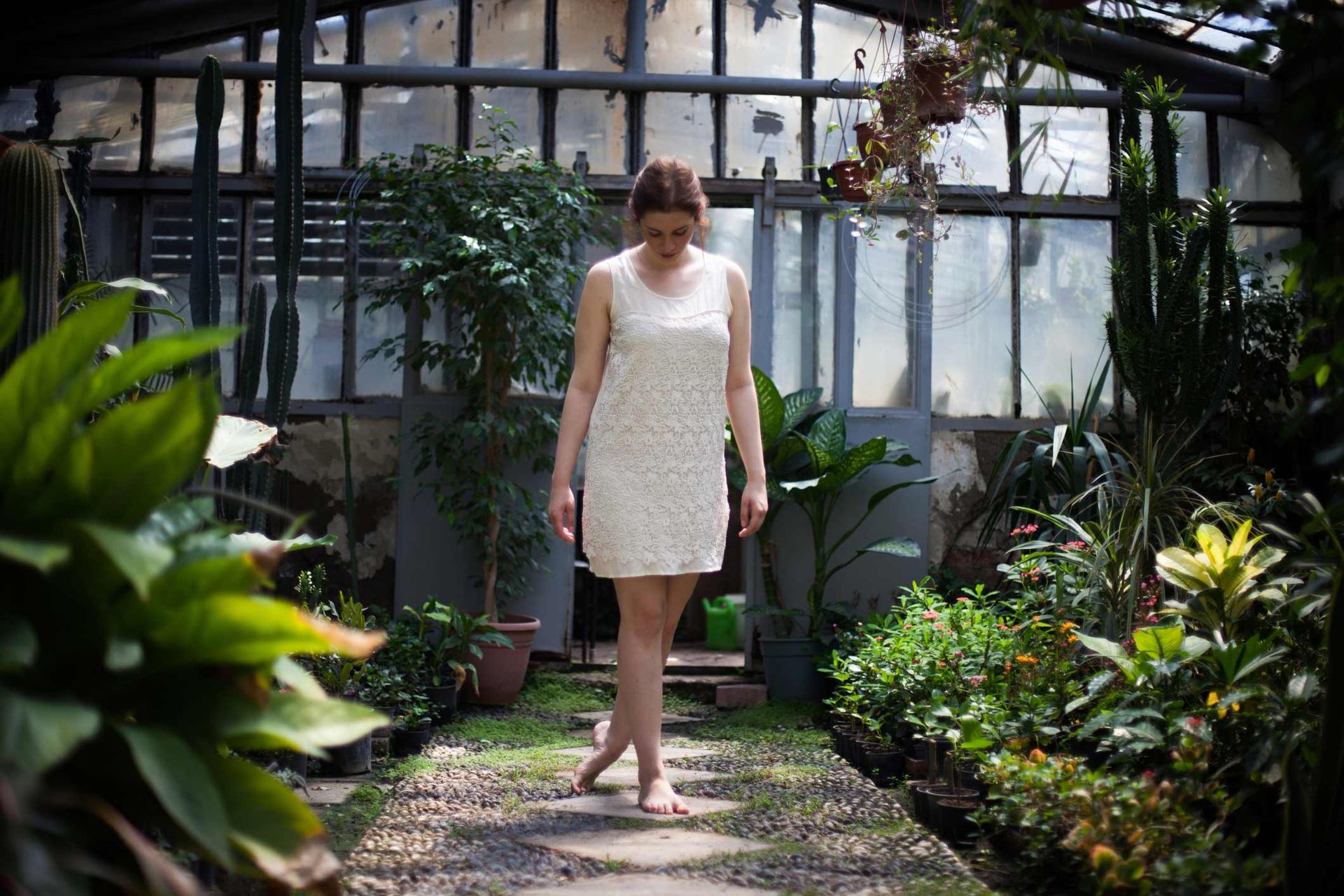 A Woman in A White Dress Is Walking Barefoot in A Greenhouse | Ballarat, VIC | Building Health Naturopathy