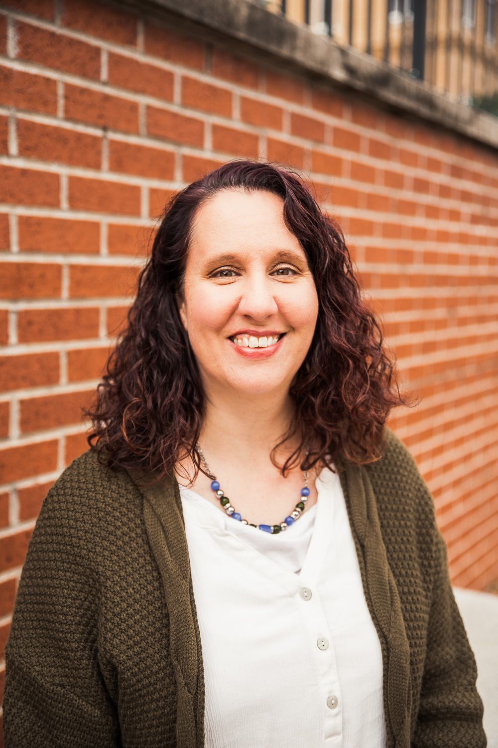 Rosemary Burns is smiling in front of a brick wall.